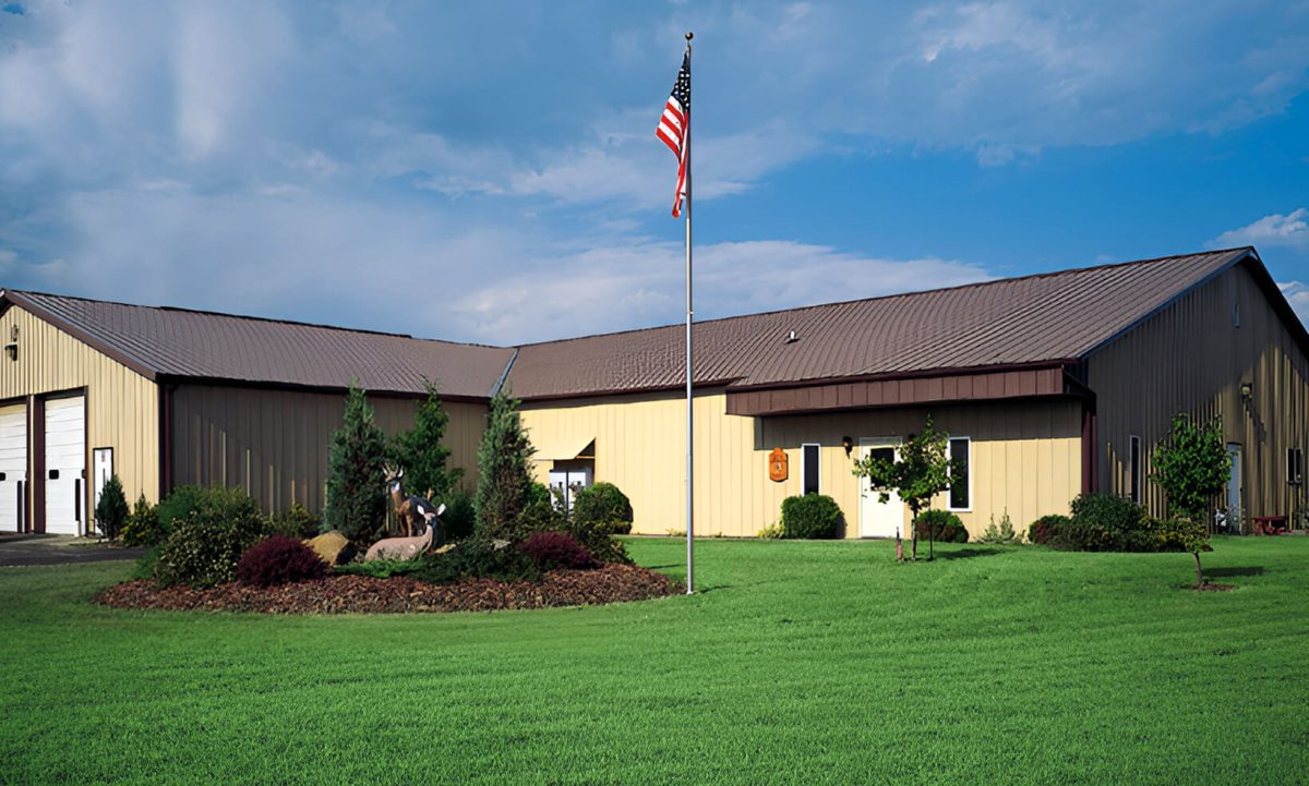 photo of our building with a flagpole and deer statues in front